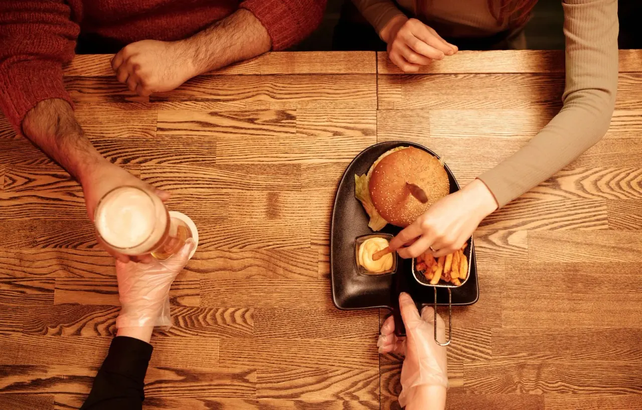 Guests sharing food and conversation across a restaurant table