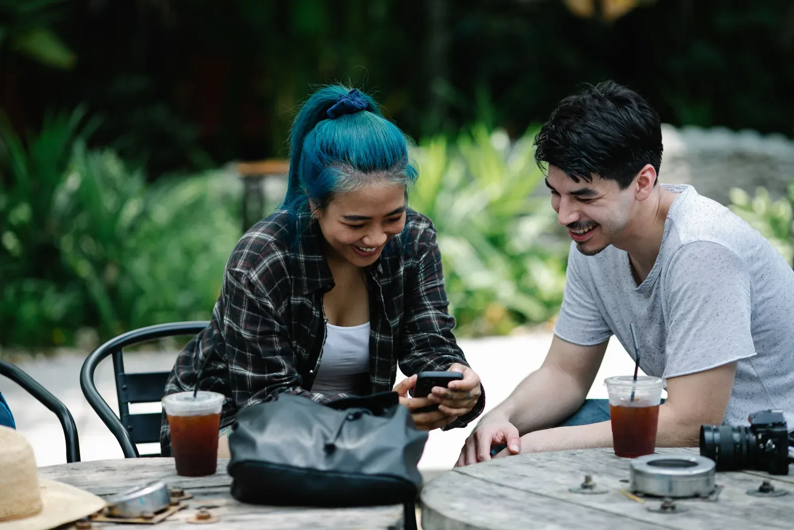 Two guests looking at a phone at an outdoor café table