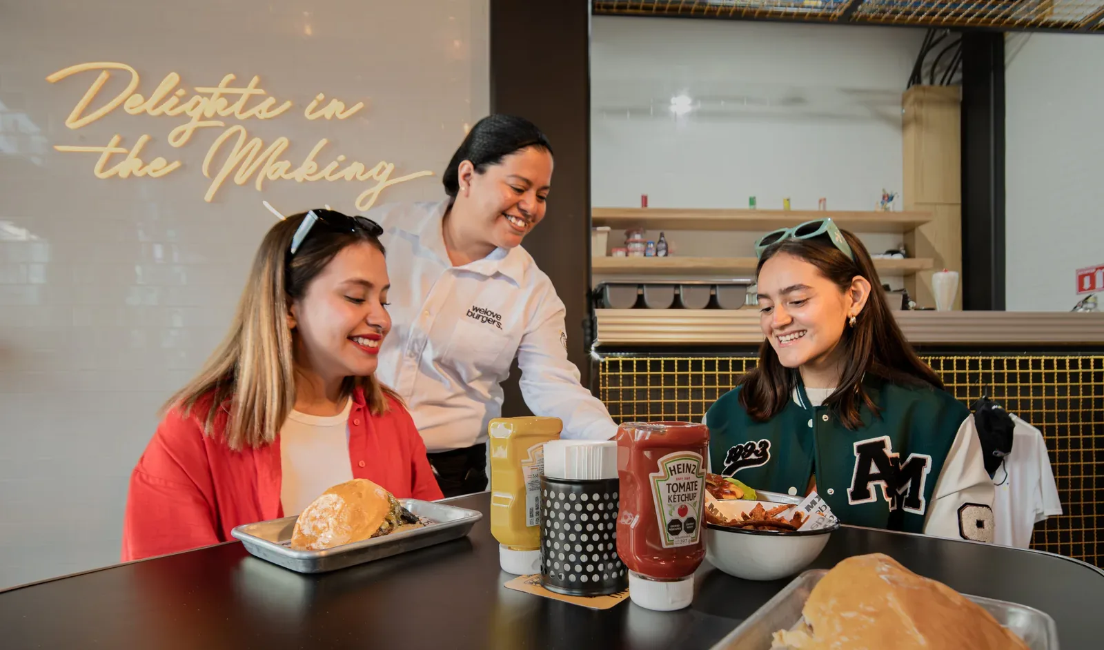 A member of staff serving food to two guests at the counter