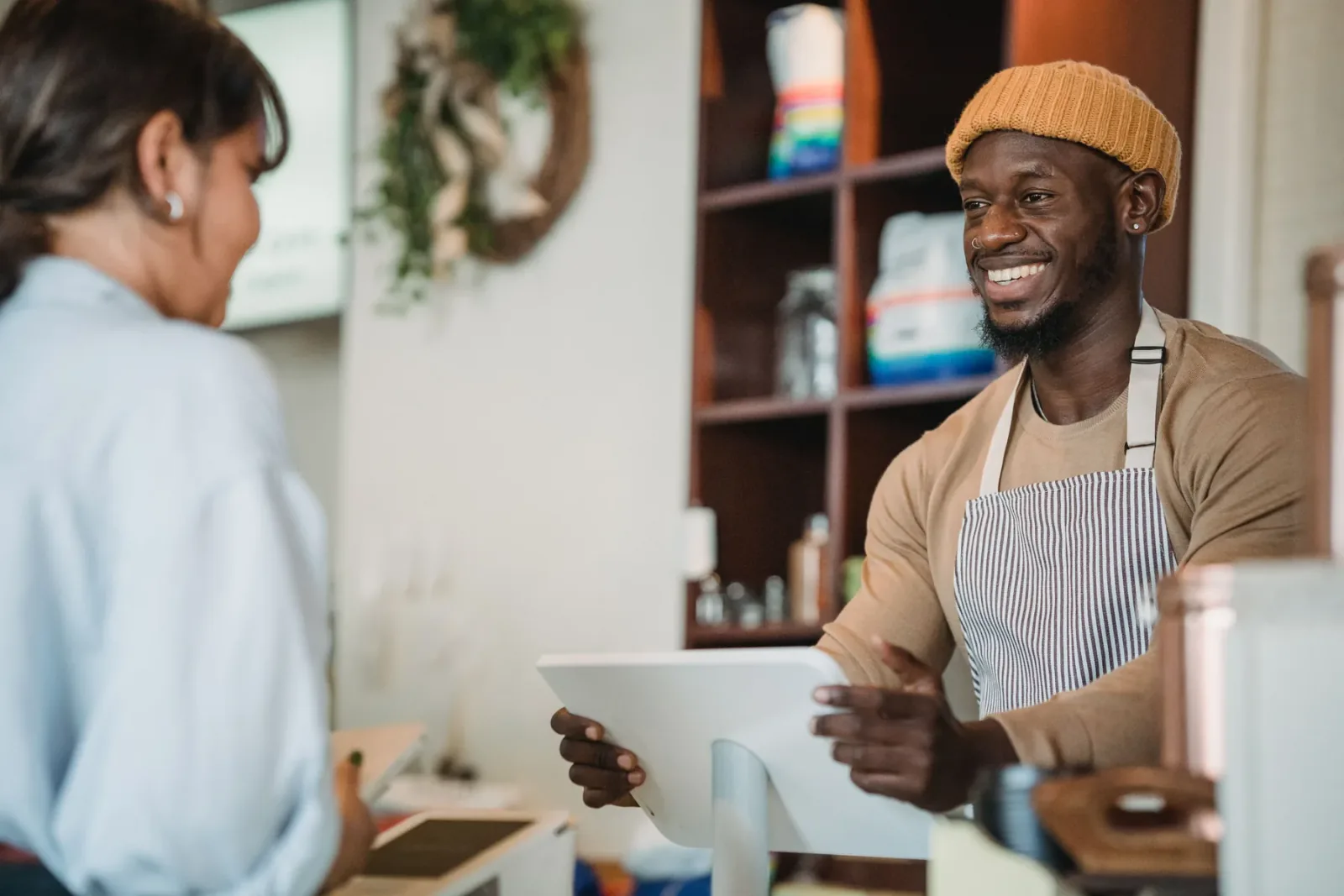 A smiling barista talking with a guest at the counter