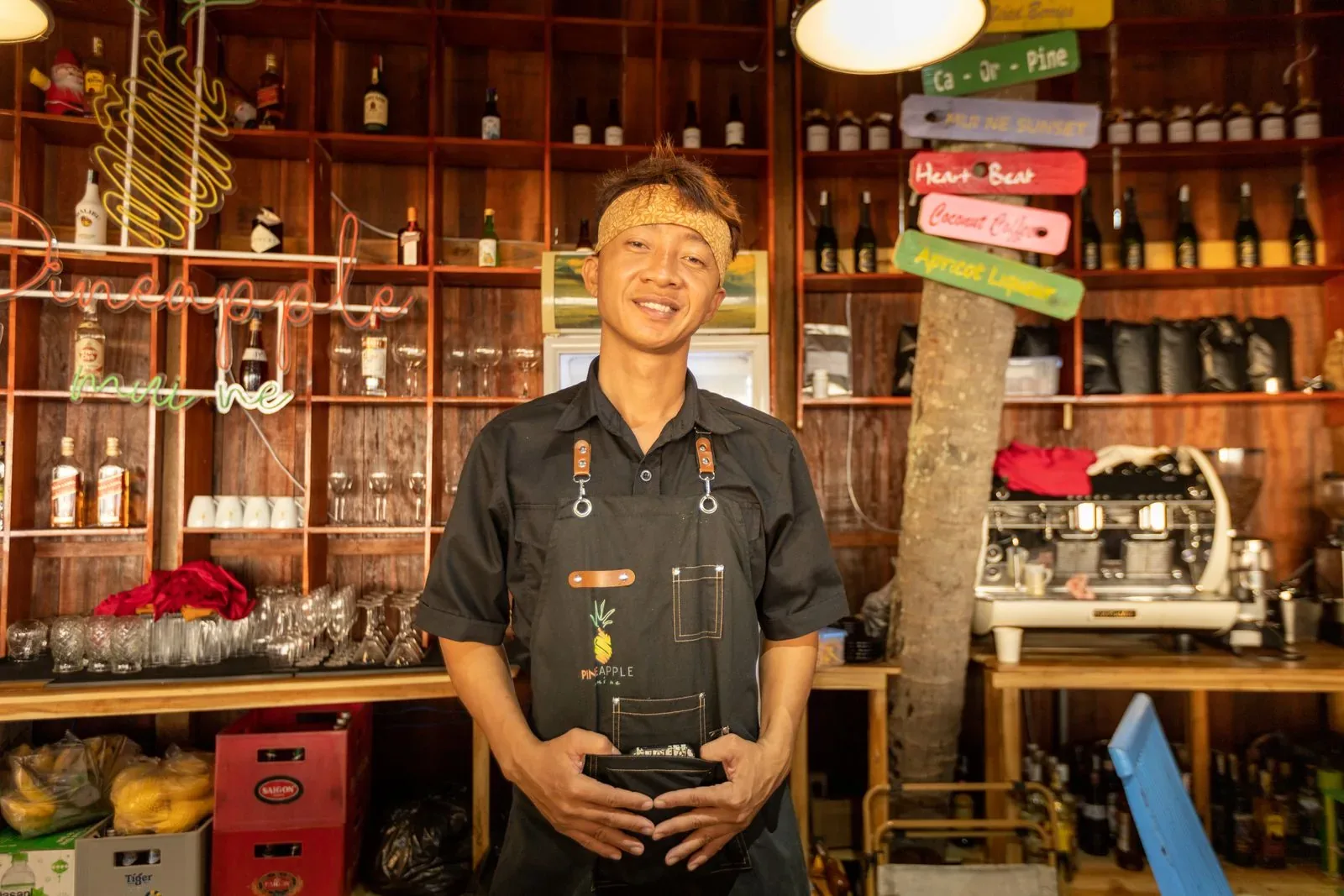 A restaurant team member standing behind a warmly lit bar