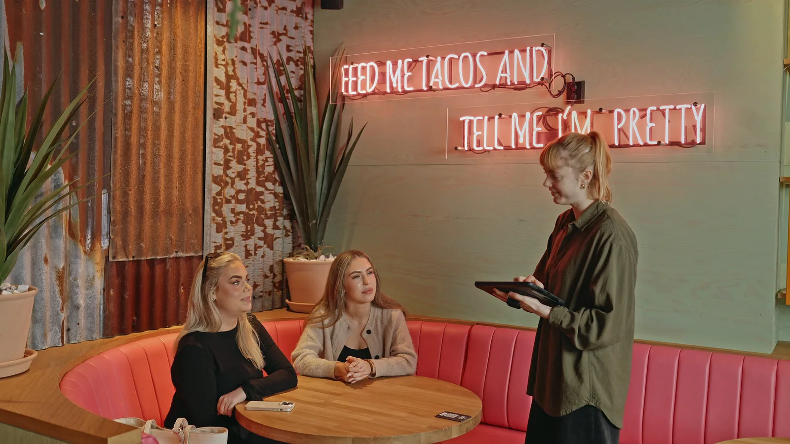 A server taking an order beside a restaurant table