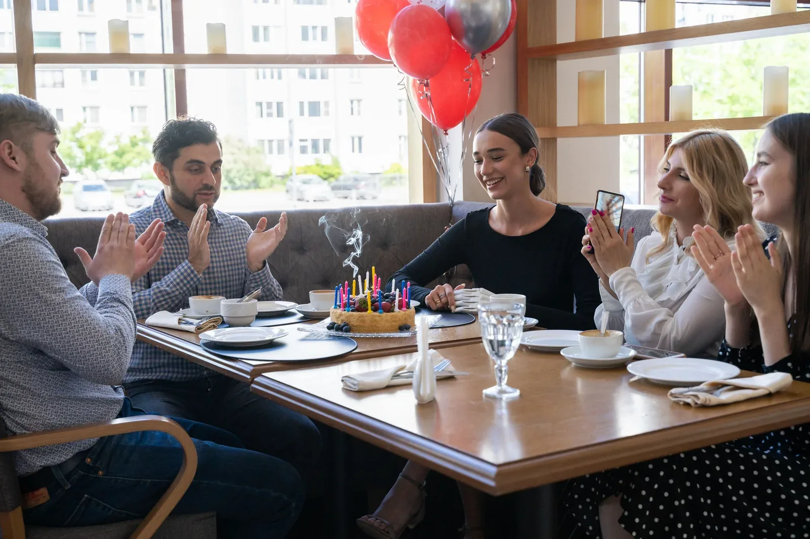 Friends celebrating a birthday around a restaurant table