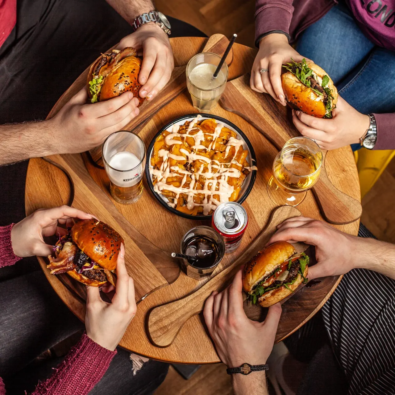 Guests sharing burgers, sides and drinks around a table
