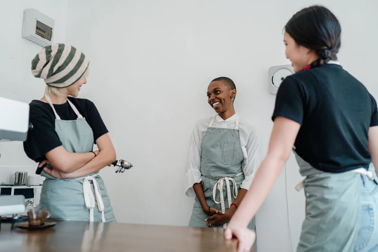 Three restaurant colleagues talking in a bright kitchen