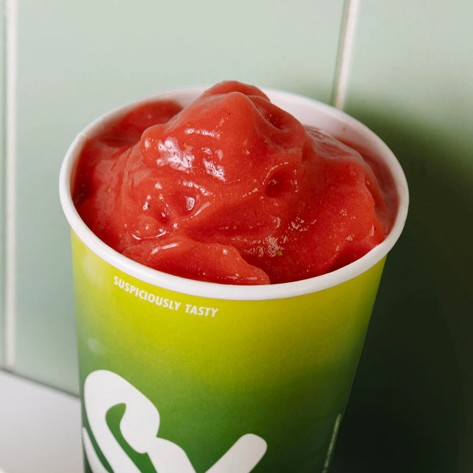 Sinh tố SmoothieXchange trong chiếc cốc xanh mang nhận diện thương hiệu