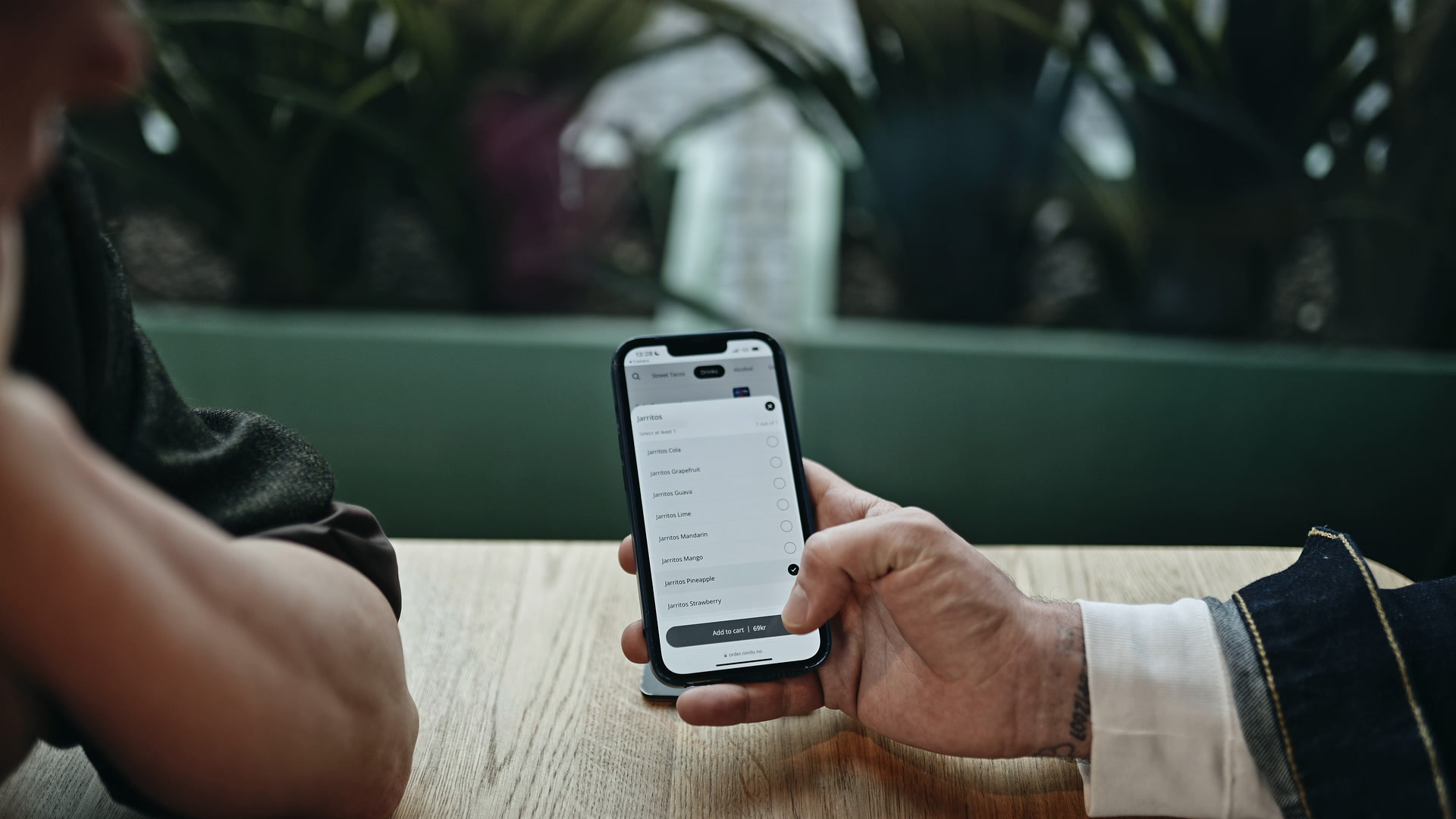 En gjest velger drikke fra restaurantens meny på mobilen