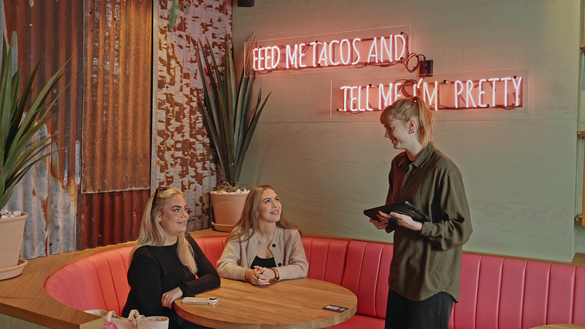 En servitør tar imot en bestilling ved et restaurantbord